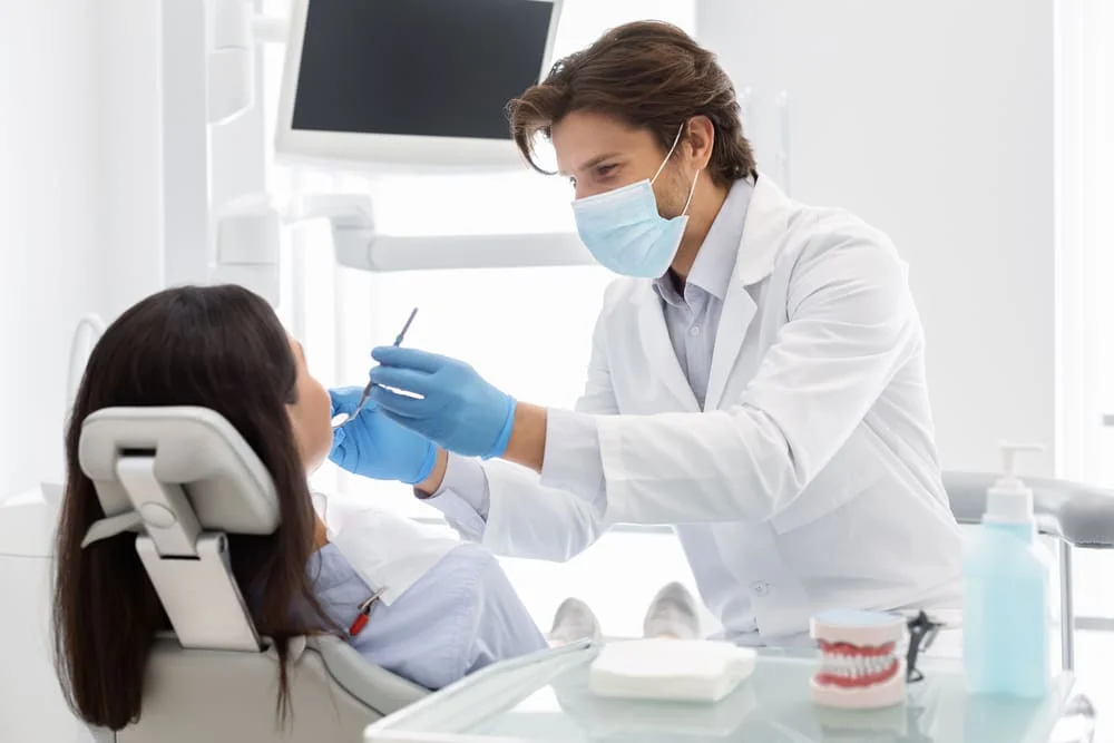 cheerful-dentist-making-regular-checkup-for-his-pa-XBH7RED.jpg